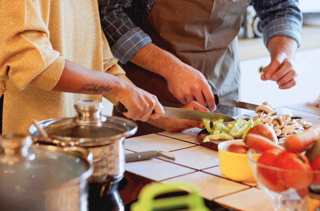 2 personnes qui coupent des légumes dans une cuisine
