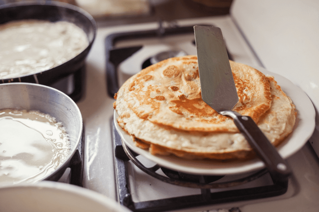 pile de pancakes avec du miel coulant dessus et des rondelles de bananes